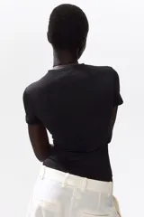 Body negro de manga corta en microfibra suave, con escote redondo y corte alto en la parte trasera.