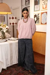 Camisa de corte clásico con cuello mao y cierre frontal oculto, confeccionada en tela de algodón con estampado de rayas verticales finas en color rojo y blanco. Presenta mangas largas con puños abotonados.