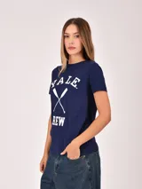 Remera de manga corta color azul marino con estampado frontal en blanco que dice "YALE CREW" y dos remos cruzados en el centro.