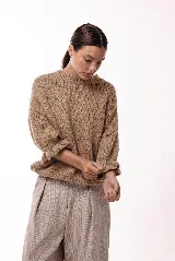 Sweater de tejido de punto con silueta relajada, cuello redondo y mangas 3/4 con puños abullonados que aportan volumen.