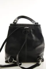 Mochila de cuero vacuno marrón con acabado pulido, solapa en forma de V y costuras decorativas. Cuenta con cremalleras laterales y asas ajustables.