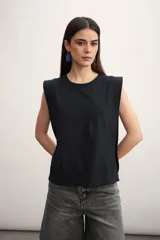 Remera musculosa negra con hombreras marcadas y cuello redondo.