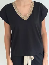 Pijama celeste de algodón con textura acanalada, compuesto por una remera de mangas cortas con escote en V y puntilla blanca, y un short con elástico en la cintura, lazo y terminación con puntilla.