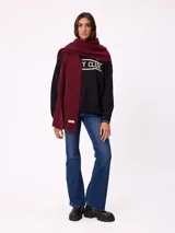 Bufanda de tejido de punto grueso en color negro, con etiqueta de la marca Rusty en uno de los extremos.