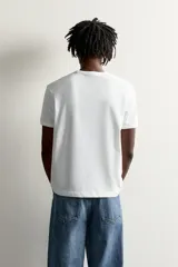 Camiseta regular fit blanca de algodón, de cuello redondo y manga corta, con estampado frontal de la colección Fruit of the Loom x Zara con temática de tenis.