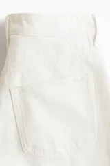 Bermudas de cinco bolsillos en denim de algodón rígido, corte de talle alto con cierre de cremallera y botón, en color blanco.