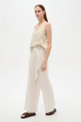 Musculosa de viscosa color beige con bordado de hojas, escote en V y tirantes finos regulables.
