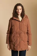Campera acolchada de nylon color tostado, con capucha, cierre frontal con botones y cordón ajustable en la cintura.