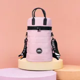 Matera estilo mochila color rosado, confeccionada en nylon acolchado con detalles en símil cuero negro. Tiene cierre metálico en la tapa, bolsillo interno, asas de mano y correa extensible con logo de la marca.