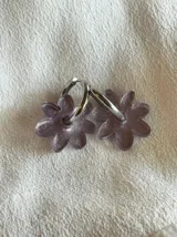 Aros de argolla metálica con dije colgante en forma de flor de acrílico color rosado.