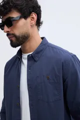 Camisa de twill azul marino con mangas largas, bolsillo en el pecho y botones contrastantes.