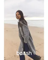 Tapado largo de tejido de punto con diseño de espiga en tonos blanco, negro y gris. Tiene cuello con solapas, doble botonadura y bolsillos laterales.