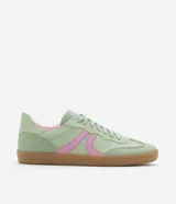 Championes de estilo retro tipo chutera, confeccionados en poliuretano color marrón con detalles en beige en los laterales y el talón. Presentan suela plana de goma color caramelo y cierre mediante cordones.