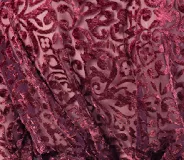 Top de encaje de terciopelo negro con diseño de arabescos, de manga larga y cierre frontal con lazos.