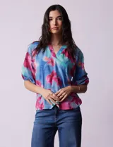 Blusa de gasa marca Sioni, con cuello a la base y escote en V. Manga 3/4 con terminación fruncida.