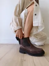 Bota Chelsea de cuero color marrón chocolate con elástico lateral negro y suela track color negro.