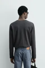 Camiseta de manga larga con cuello redondo y cierre frontal de botonadura tipo henley. Confeccionada en tejido de algodón y seda, con un corte relajado.