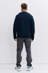 Pantalón de jean corte regular, color gris oscuro, con diseño de cinco bolsillos y cierre frontal con botón y cremallera.