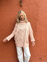 Polera de tejido de punto con diseño de ochos, color rosa viejo, de corte oversize y cuello alto, con mangas largas y puños acanalados.
