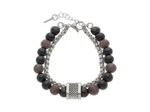 Pulsera doble de acero quirúrgico con cuentas de piedra ónix negra y piedras marrones jaspeadas. Presenta un cilindro metálico texturizado en el centro y cierre de mosquetón con cadena de alargue.