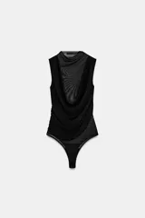 Body negro de tul con cuello alto y sisas amplias. Diseño drapeado en el frente y cierre inferior con broches a presión.