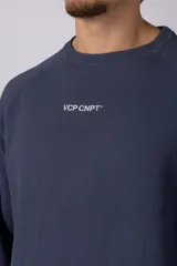 Buzo de cuello redondo y manga larga, confeccionado en tejido de punto acanalado de color negro. Presenta un diseño minimalista con un pequeño logo estampado en el pecho y un corte relajado.