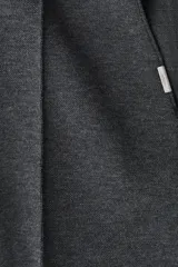 Pantalón tipo jogger de punto en tono gris oscuro, con cintura elástica y cordón ajustable. Presenta un pliegue cosido en el frente de cada pierna, bolsillos laterales y un bolsillo insertado trasero.