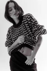 Buzo de punto grueso con diseño bicolor en patrón geométrico, de calce holgado y mangas largas.