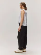 Pantalón de lino color blanco crudo, de corte barrel, con bolsillos laterales y costuras pespunteadas a contratono.