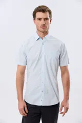 Camisa de manga corta de algodón en color celeste con microdiseño geométrico a cuadros, cuello camisero y bolsillo frontal con logo bordado.