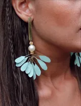 Aros colgantes con base dorada, pétalos celestes y perla blanca.