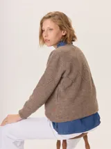 Buzo de lana color marrón topo, con cuello en V y diseño de punto calado en rombos en el frente y mangas.