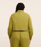 Campera corta color verde oliva, confeccionada en viscolino, con cuello inglés, abotonada adelante, bolsillos y manga larga ajustada.