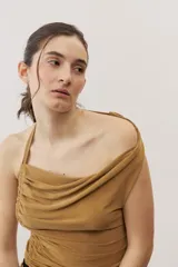 Top negro con diseño cruzado tipo halter, escote pronunciado y fruncido lateral.