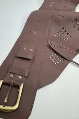 Faja de cuero vacuno color beige, con diseño de calados geométricos, costuras decorativas y cierre frontal con hebilla metálica.