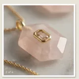 Collar de acero con baño de oro, compuesto por una cadena fina y un dije hexagonal de cuarzo rosa natural con una circonia rectangular engastada en el centro.