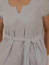 Vestido corto celeste a rayas verticales, con cuello en V, mangas cortas abullonadas, corte a la cintura con frunces y lazo para atar.