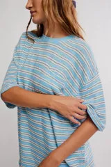 Remera oversize de manga corta a rayas celestes y blancas, con cuello redondo y un bolsillo aplicado en el pecho.
