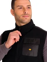 Chaleco de polar negro con cierre frontal, cuello alto y bolsillo en el pecho con solapa y logo de la marca CAT.