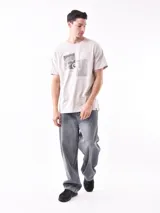 Remera color arena con cuello redondo y estampado pequeño en el pecho.