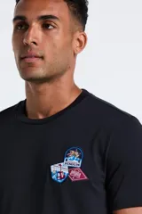 Remera de manga corta color negro con cuello redondo y parches decorativos en el pecho.