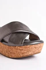 Sandalia color beige con plataforma de corcho y tiras cruzadas de cuero.