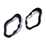 Par de aros colgantes negros con forma irregular y diseño retorcido.