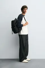 Camiseta de manga larga con estructura waffle, corte regular fit. El cuerpo es de color blanco crudo y las mangas raglán son de color azul marino. Tiene cuello redondo a contraste.