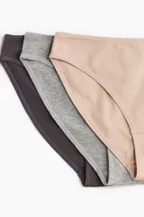 Pack de siete bombachas de punto acanalado en colores gris, blanco, beige, rosa, negro y gris oscuro, con cintura estándar, refuerzo interior y cobertura media en la parte de atrás.