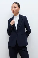 Blazer clásico de corte entallado, color negro, con cierre frontal de un botón, solapas de muesca y bolsillos laterales con solapa.