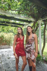 Vestido corto con estampado abstracto en tonos rosados, escote en V y breteles finos que se atan al cuello. Tiene corte en la cadera y falda con ruedo irregular y pico en lateral.