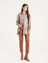 Pantalón negro estilo jeanero confeccionado en gabardina elastizada con terminación metalizada, pierna recta con largo por arriba del tobillo, cierre delantero y botón.