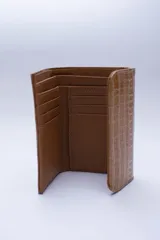 Billetera negra de cuero con textura tipo cocodrilo, con múltiples ranuras para tarjetas y billetes.