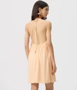 Enterito corto de viscosa color salmón con diseño de cuello halter, espalda abierta y caída fluida.